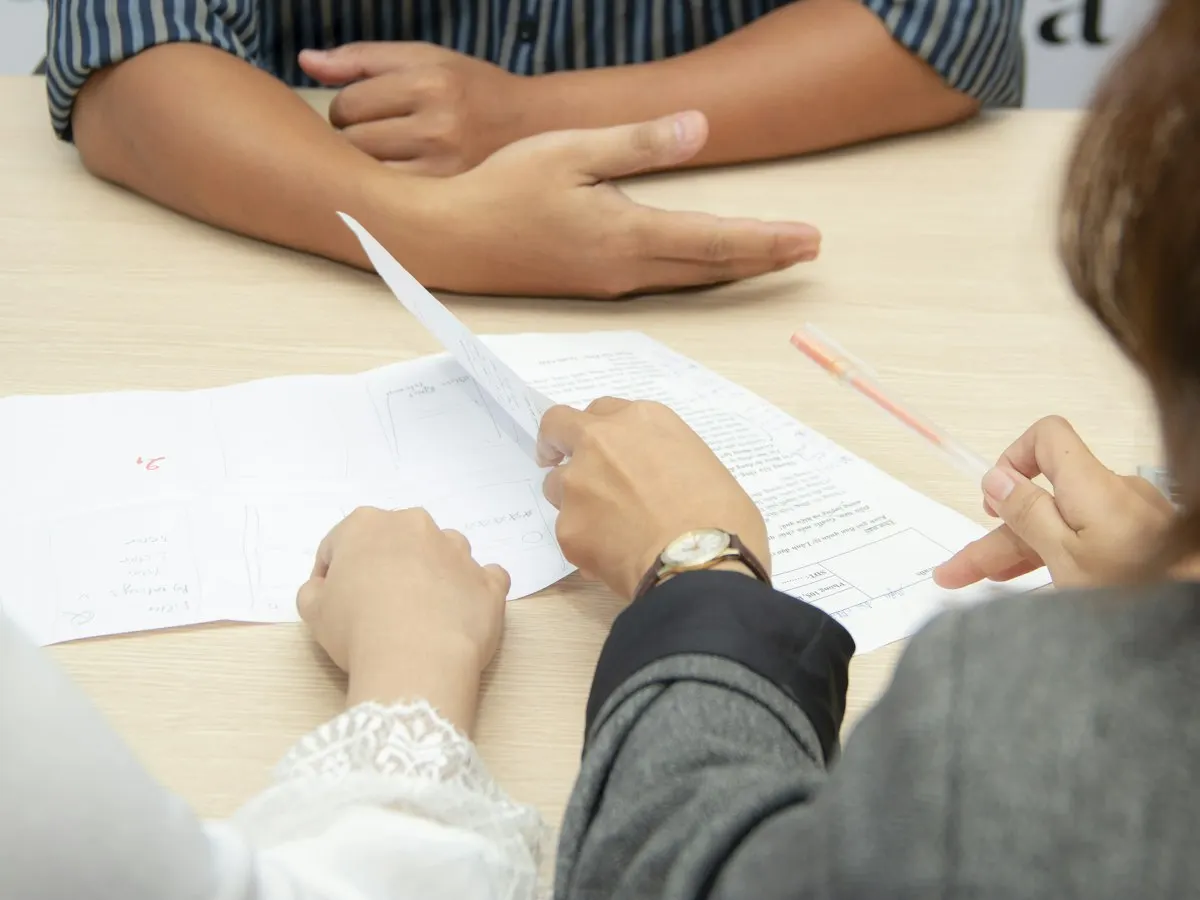 Twee mensen bespreken documenten aan een tafel