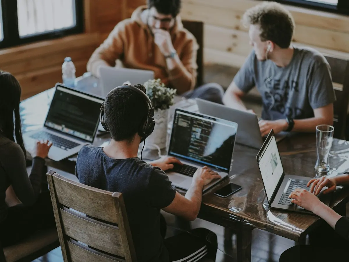 Collega's werken samen aan laptops rond een tafel