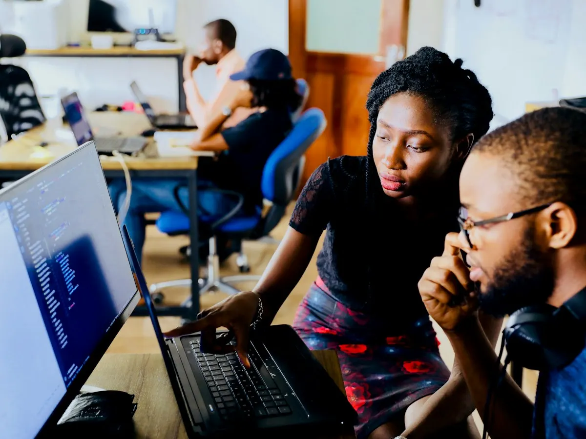 Collega's werken samen aan een computer